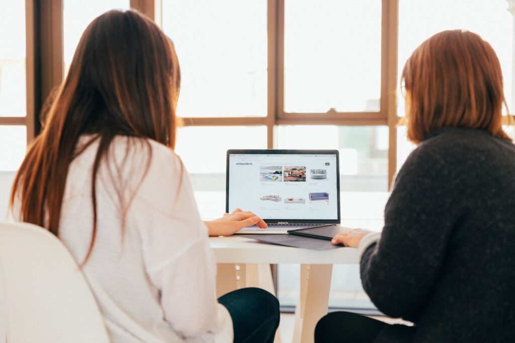 Women looking at resources on laptop.