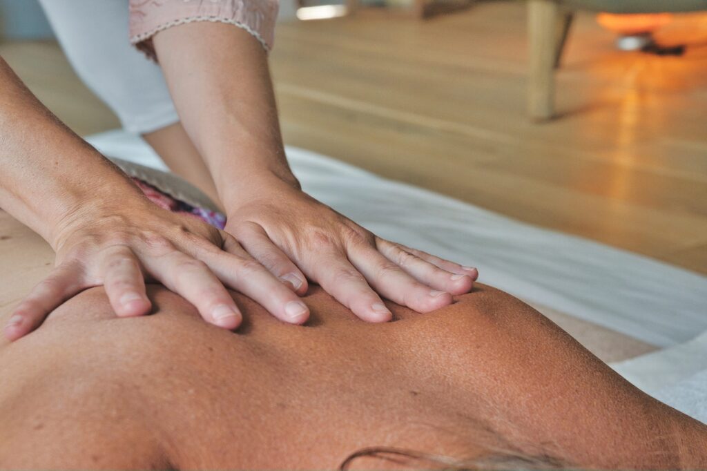 Massage Therapies photo of therapist massaging the back of a woman.