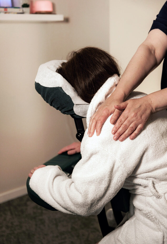 Woman receiving acupressure chair massage.